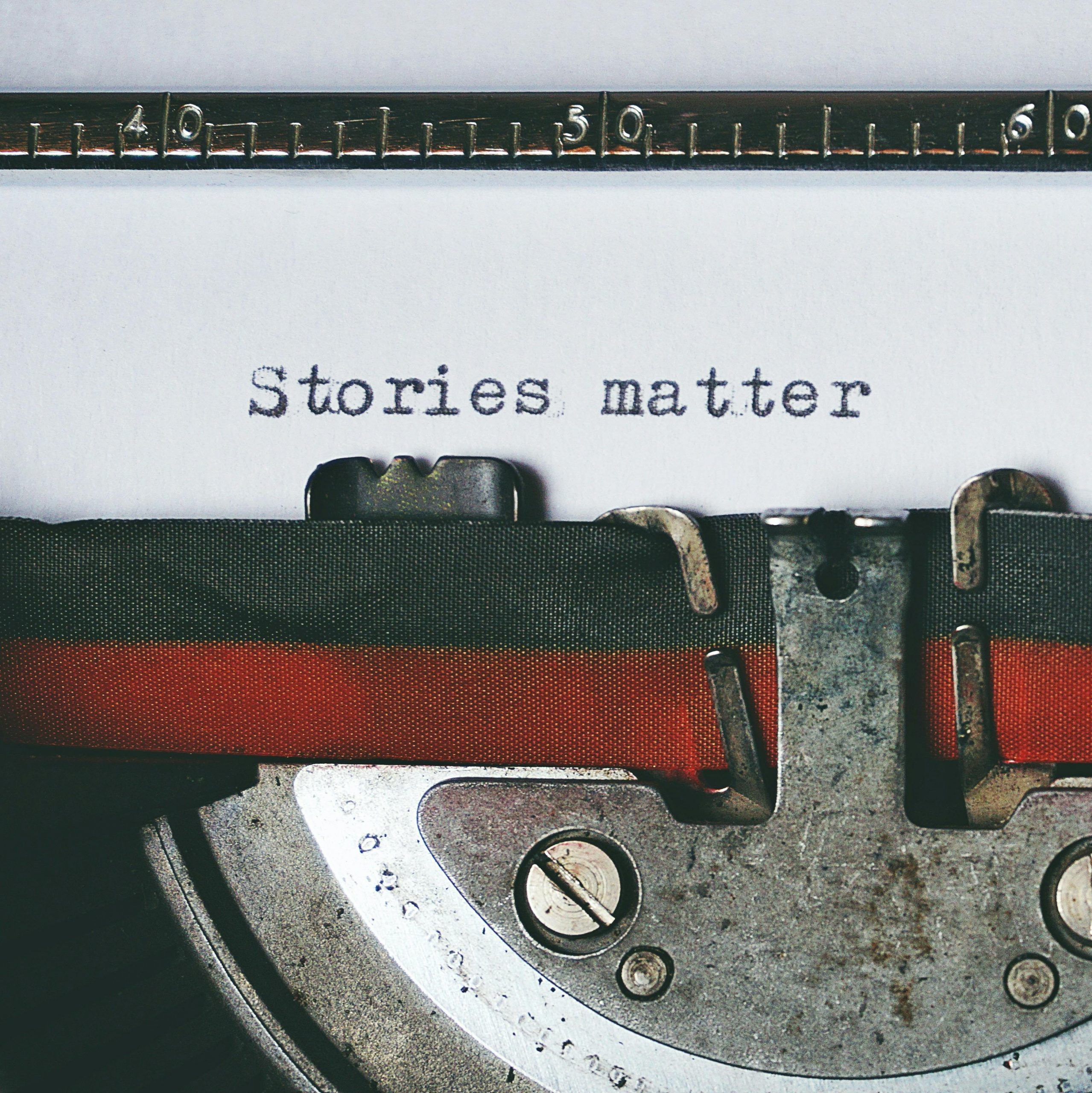 Close-up of a vintage typewriter with the text 'Stories matter' typed on paper, evoking nostalgia.